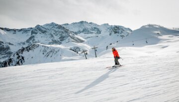 © Adelboden-Lenk Skifahrer auf einer schneebedeckten Piste vor Bergkulisse. | © Adelboden-Lenk