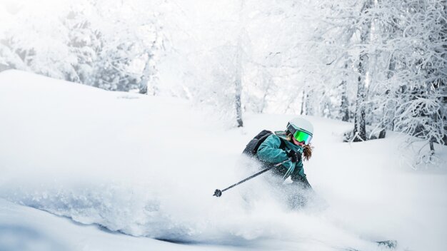 Skifahrerin fährt durch Tiefschnee im verschneiten Wald. | © Atomic Austria GmbH