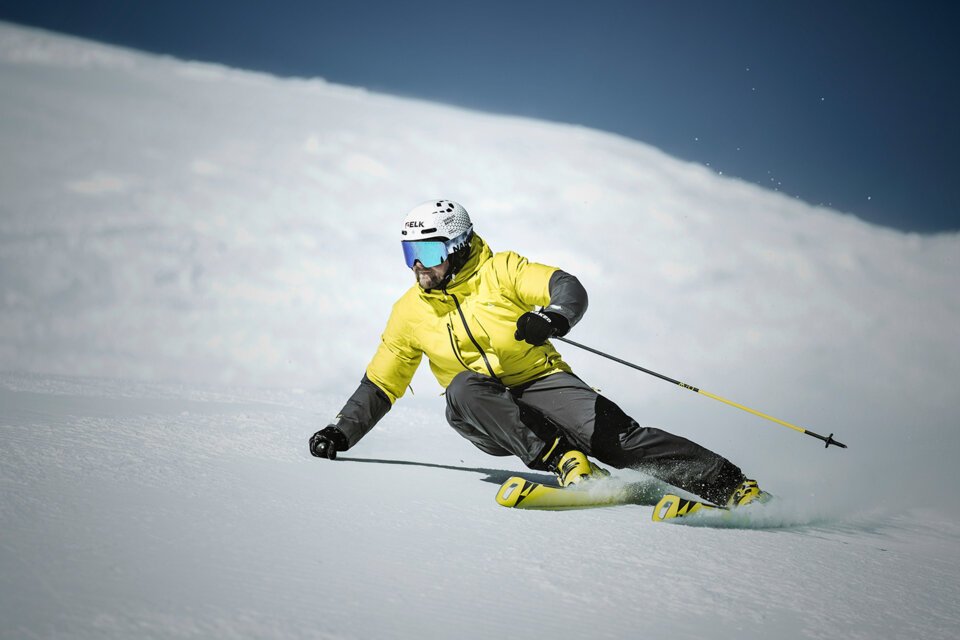 © Fischer Sports GmbH Skifahrer in gelber Jacke fährt eine schneebedeckte Piste hinunter. | © Fischer Sports GmbH
