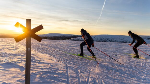 Zwei Langläufer im verschneiten Gelände bei Sonnenuntergang. | © Fischer Sports GmbH