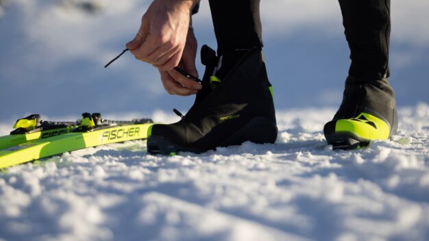 Person schnürt Skischuh im Schnee. | © Fischer Sports GmbH