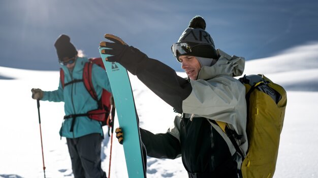 Zwei Skitourengeher im Schnee, einer hält Ski in der Hand. | © Fischer Sports GmbH