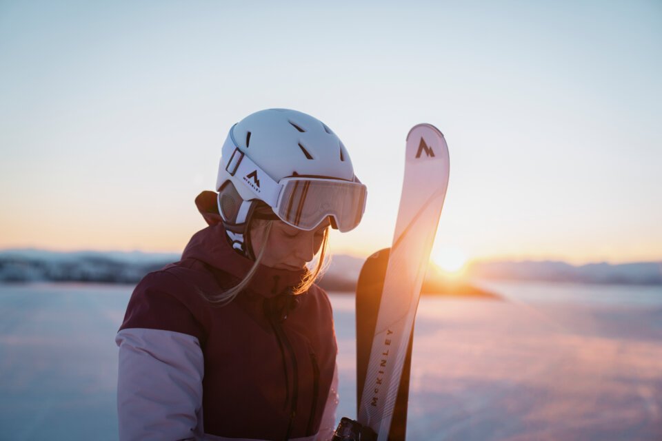 © INTERSPORT International Corporation GmbH Skifahrerin mit Helm und Skiern im Sonnenuntergang | © INTERSPORT International Corporation GmbH