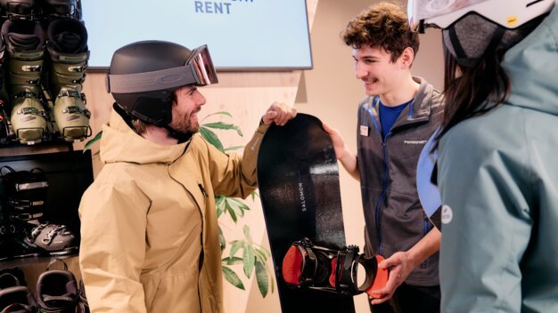Mann mit Snowboard in einem Intersport-Geschäft. | © ARMIN WALCHER