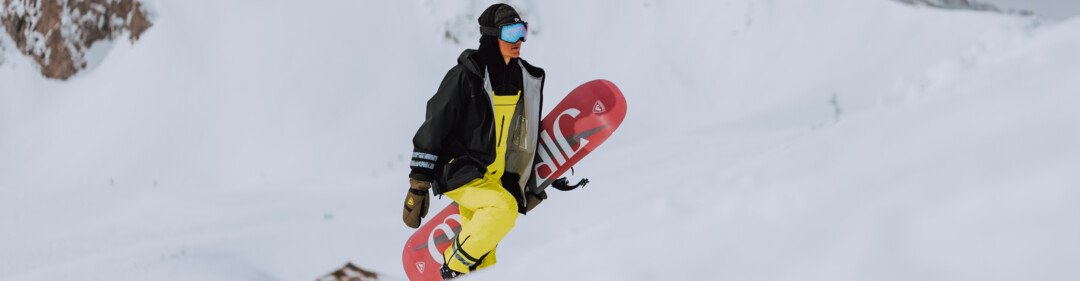 Snowboarder trägt Snowboard in verschneiter Berglandschaft. | © Oliver Godbold photography / ROSSIGNOL
