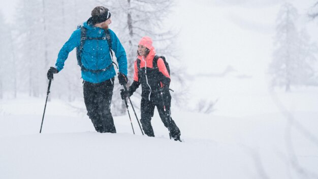 Zwei Personen wandern im Schnee mit Stöcken. | © IIC/McKINLEY