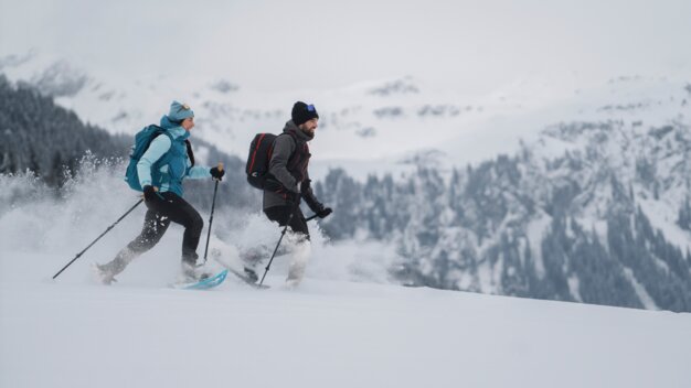 Zwei Personen beim Schneeschuhwandern in verschneiter Landschaft. | © INTERSPORT International Corporation GmbH