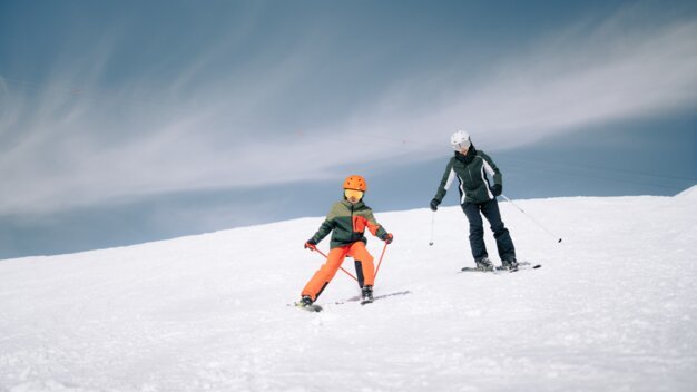 Zwei Skifahrer auf einer verschneiten Piste