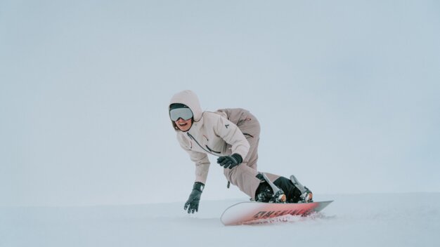 Eine Frau fährt Snowboard im Schnee.