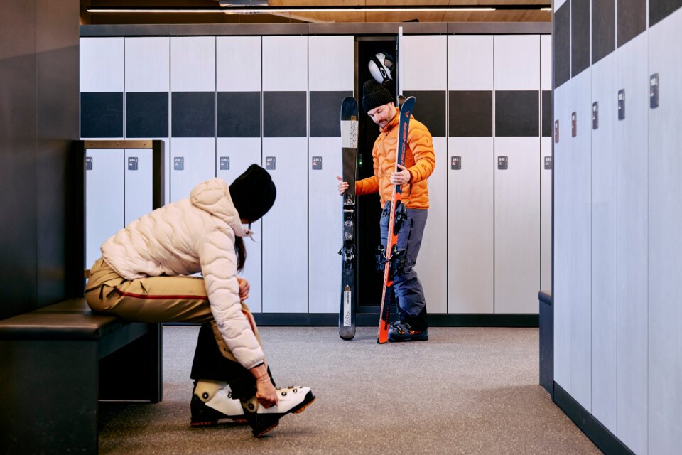 © ARMIN WALCHER Zwei Personen bereiten sich in einem Skiraum vor. | © ARMIN WALCHER