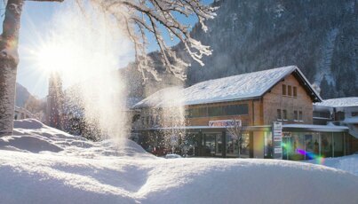 Intersport-Geschäft in einem Tal in verschneiter Winterlandschaft